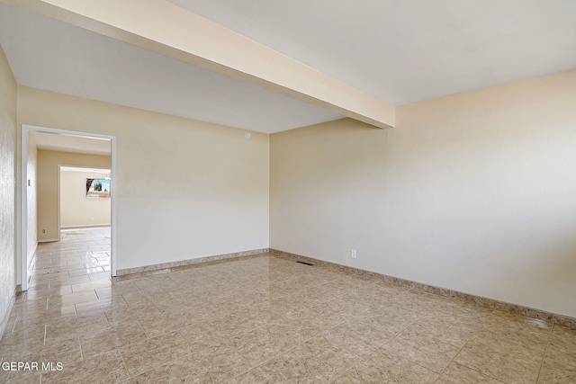 spare room with beam ceiling