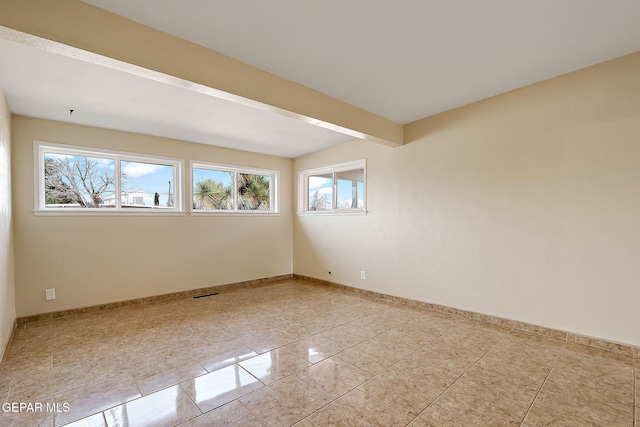 spare room with beamed ceiling