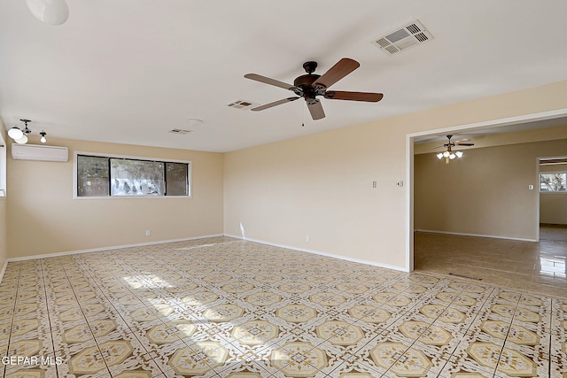 tiled spare room with ceiling fan and a wall unit AC