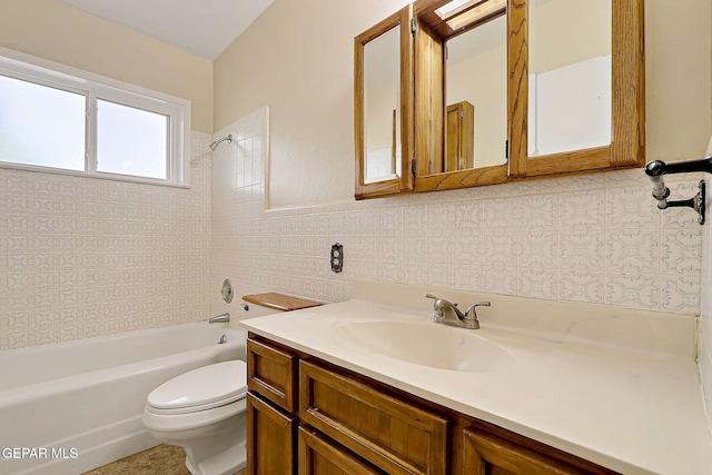 full bathroom with tile walls, vanity, tiled shower / bath combo, and toilet