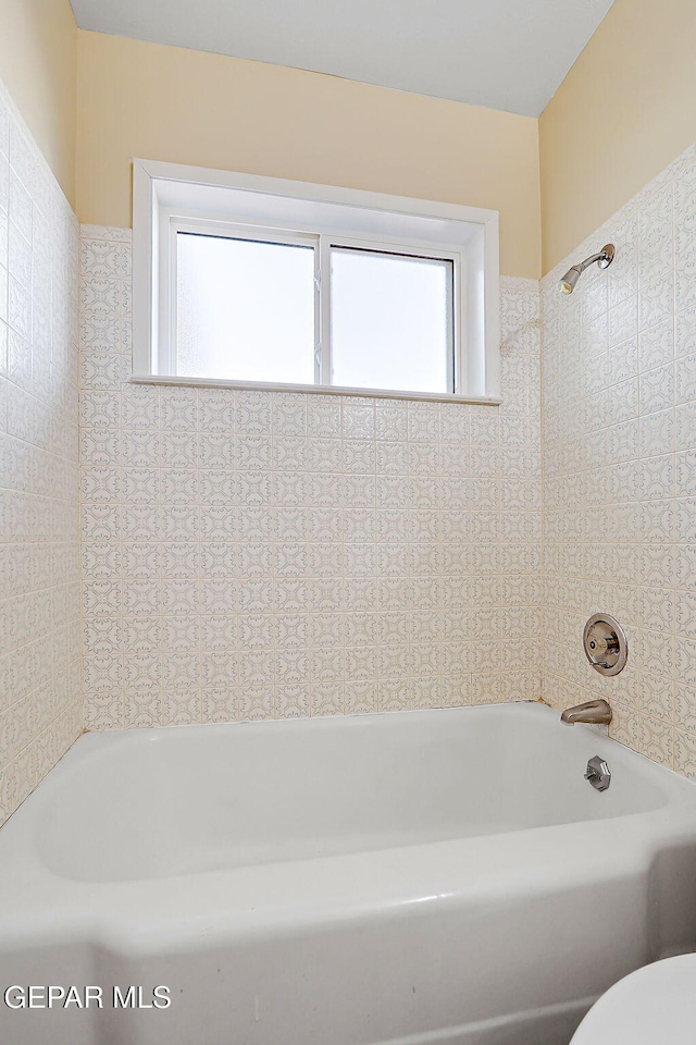 bathroom featuring a tub to relax in and toilet