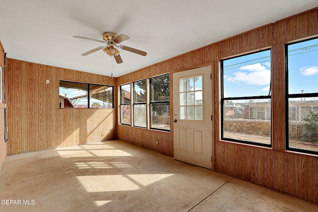 unfurnished sunroom with ceiling fan