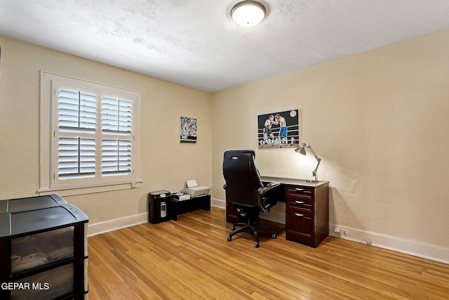 office featuring light hardwood / wood-style floors and a textured ceiling