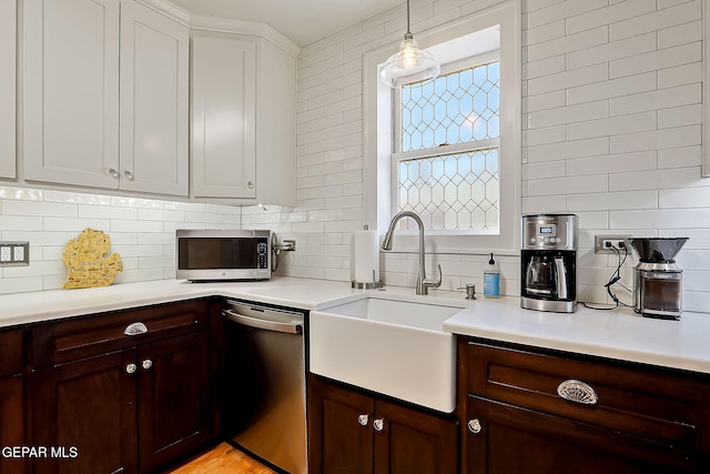 kitchen featuring pendant lighting, sink, appliances with stainless steel finishes, backsplash, and dark brown cabinetry