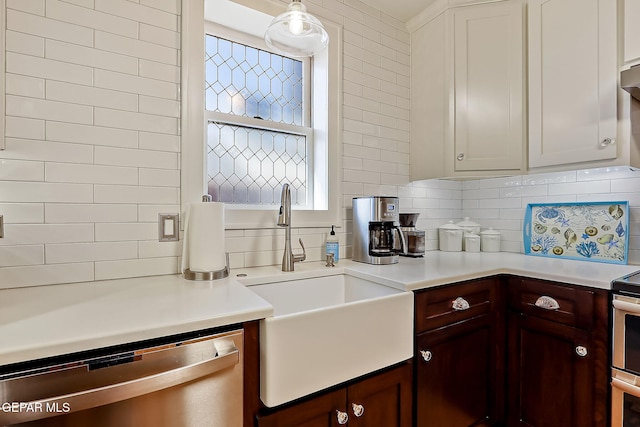 kitchen featuring stainless steel dishwasher, decorative light fixtures, sink, and backsplash