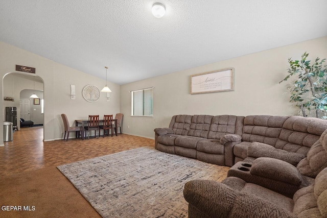 carpeted living room featuring vaulted ceiling and a textured ceiling