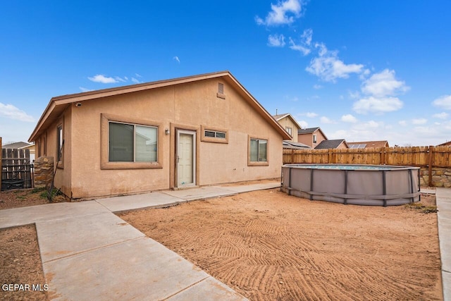 rear view of house with a fenced in pool