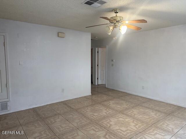 empty room with a textured ceiling and ceiling fan