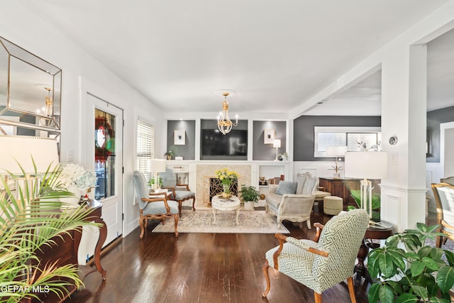 interior space with a fireplace, a notable chandelier, and dark wood-type flooring