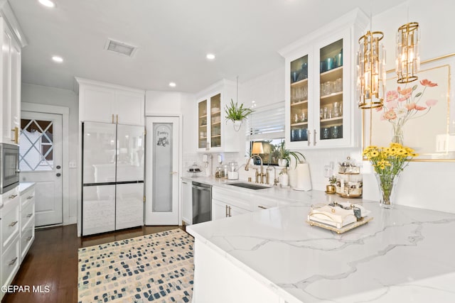 kitchen featuring sink, light stone countertops, decorative light fixtures, stainless steel dishwasher, and white fridge