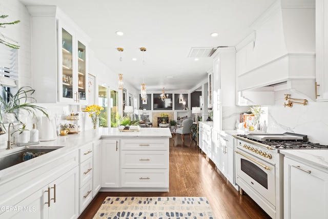 kitchen featuring sink, white stove, light stone counters, custom range hood, and white cabinets