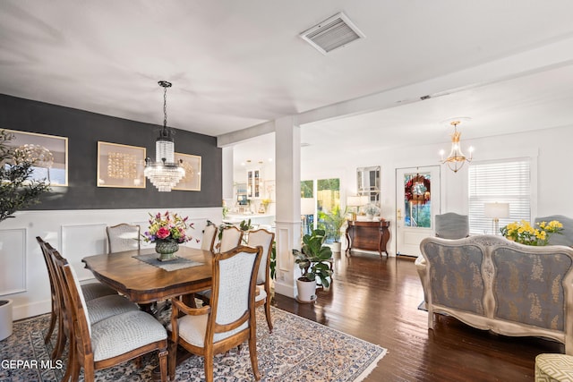 dining space featuring dark hardwood / wood-style floors and a notable chandelier