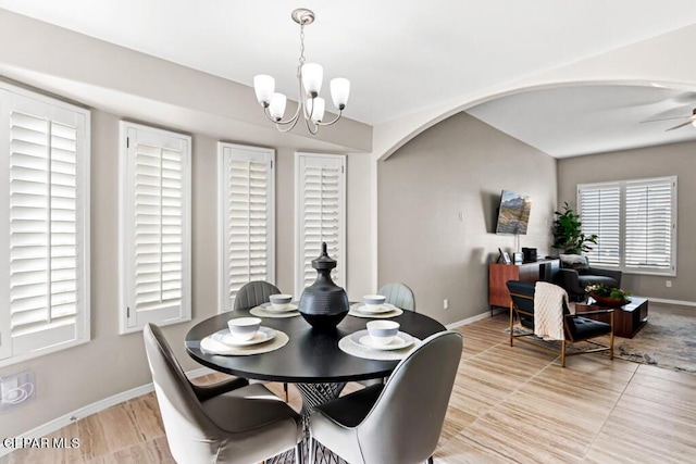 dining area featuring ceiling fan with notable chandelier