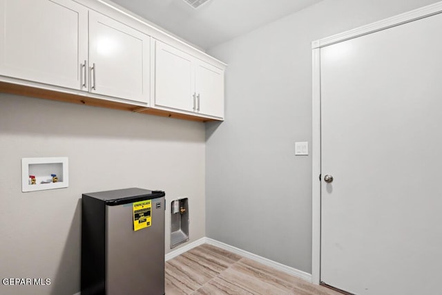 washroom featuring cabinets, hookup for a washing machine, and light hardwood / wood-style floors