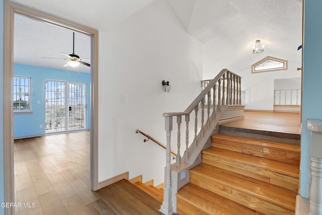 stairs featuring wood-type flooring, ceiling fan, and a textured ceiling