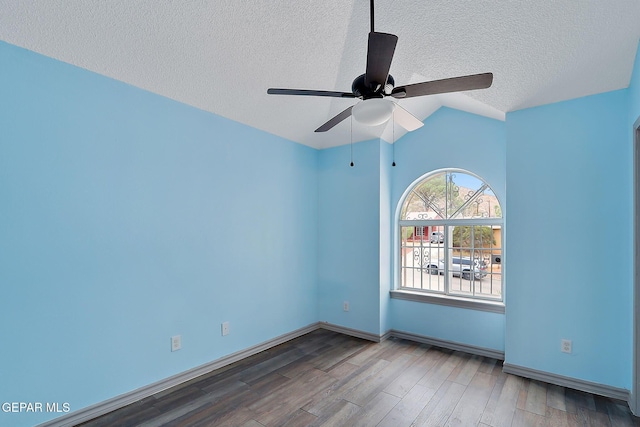 spare room featuring wood-type flooring, vaulted ceiling, ceiling fan, and a textured ceiling