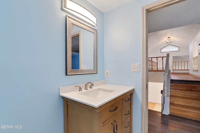 bathroom featuring vanity, hardwood / wood-style flooring, and lofted ceiling