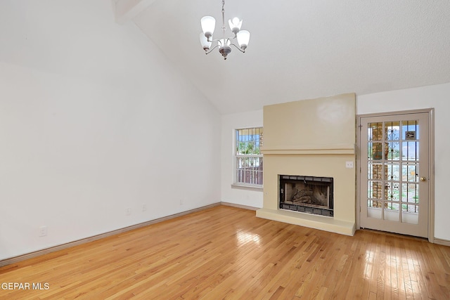 unfurnished living room featuring beamed ceiling, high vaulted ceiling, hardwood / wood-style floors, and a notable chandelier