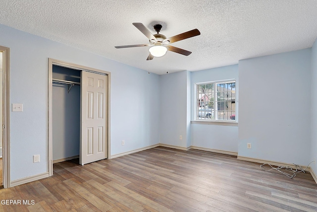 unfurnished bedroom featuring ceiling fan, light hardwood / wood-style floors, a closet, and a textured ceiling