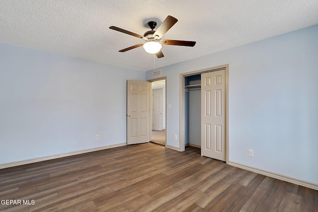 unfurnished bedroom featuring ceiling fan, wood-type flooring, a closet, and a textured ceiling