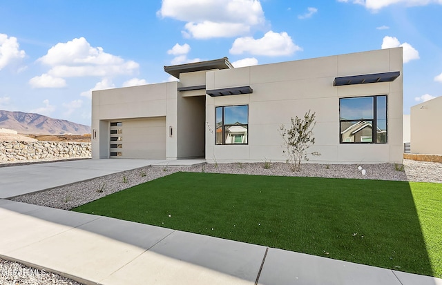 contemporary house featuring a garage, a mountain view, and a front yard