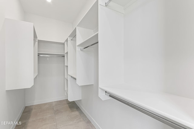 walk in closet with light tile patterned floors