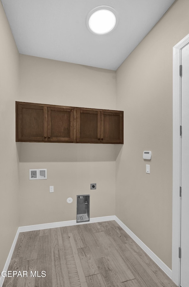 clothes washing area featuring hookup for a washing machine, cabinets, hookup for a gas dryer, hookup for an electric dryer, and light wood-type flooring