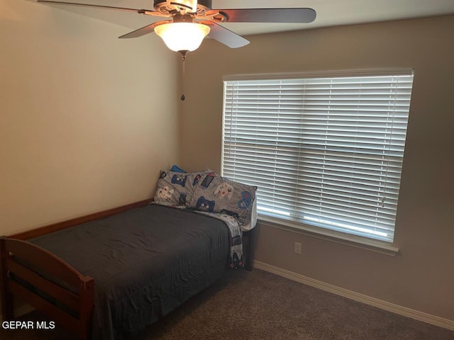 unfurnished bedroom with dark carpet and ceiling fan