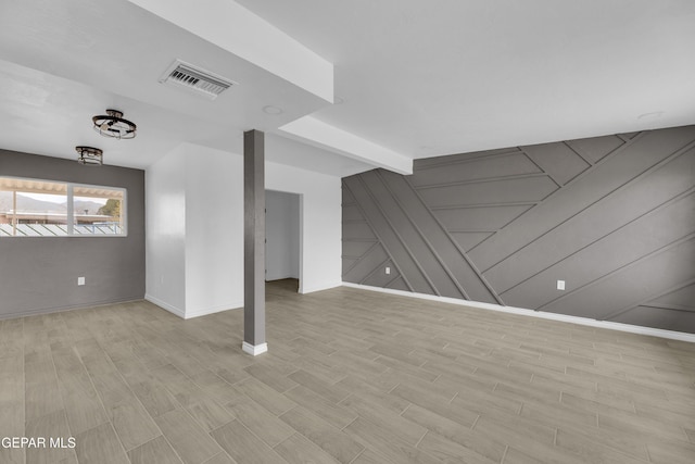 additional living space with wood walls and light wood-type flooring