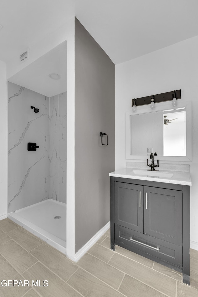 bathroom with vanity and tiled shower