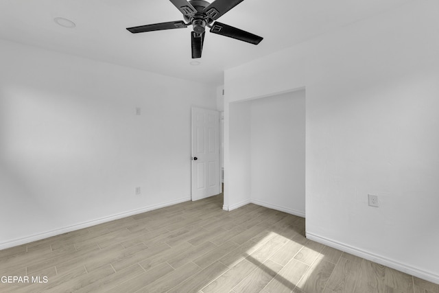 spare room with ceiling fan and light wood-type flooring