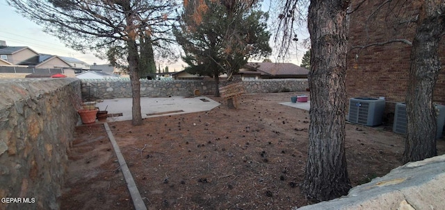 yard at dusk featuring central air condition unit