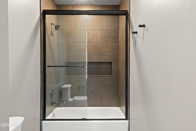 bathroom with bath / shower combo with glass door and toilet