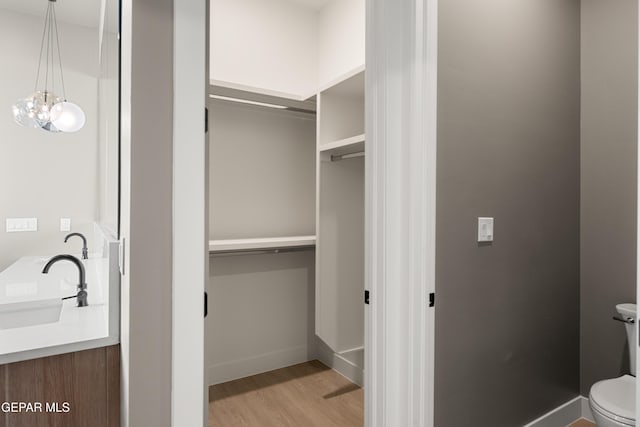 bathroom with hardwood / wood-style flooring, vanity, and toilet