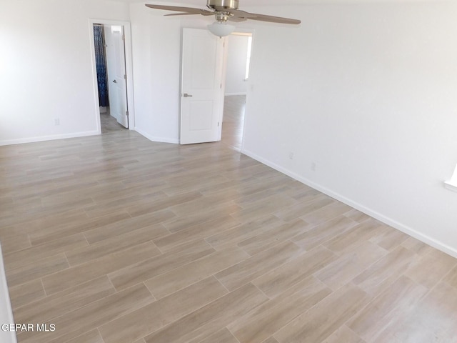 unfurnished room with ceiling fan, baseboards, and light wood-type flooring