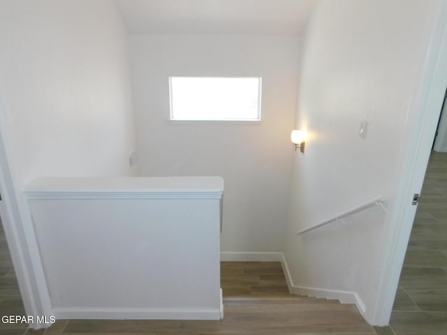 stairway featuring baseboards and wood finished floors