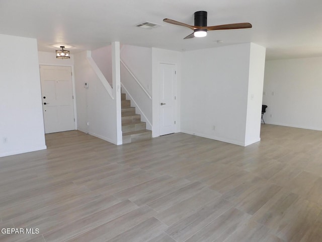 unfurnished living room featuring stairway, a ceiling fan, light wood-type flooring, and visible vents