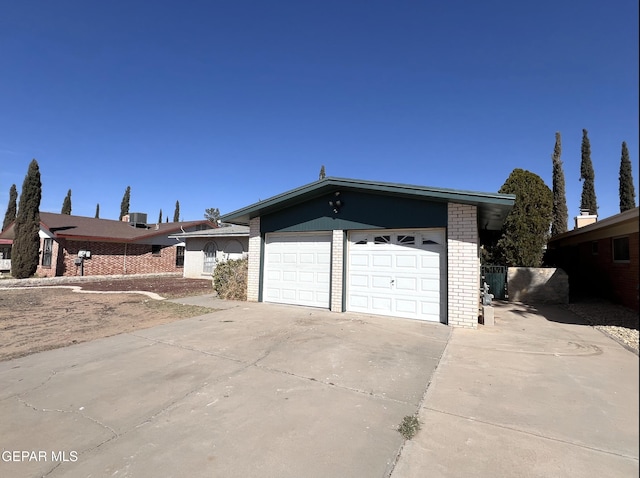 view of front of house with a garage, driveway, and brick siding