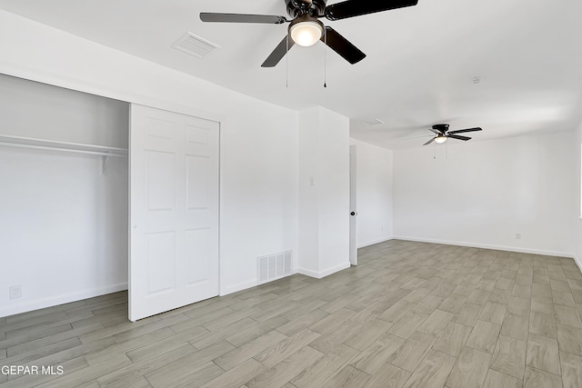 unfurnished bedroom with ceiling fan, light wood-type flooring, and a closet