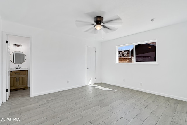 unfurnished bedroom featuring sink, ensuite bath, light hardwood / wood-style flooring, and ceiling fan