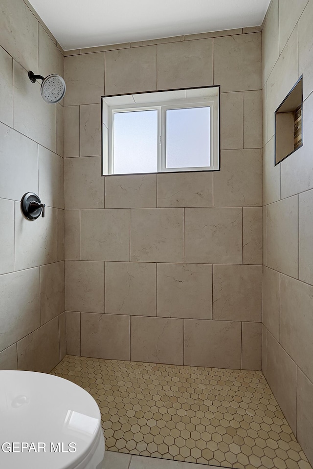 bathroom with toilet and tiled shower