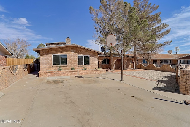 view of front facade featuring basketball court and a patio area