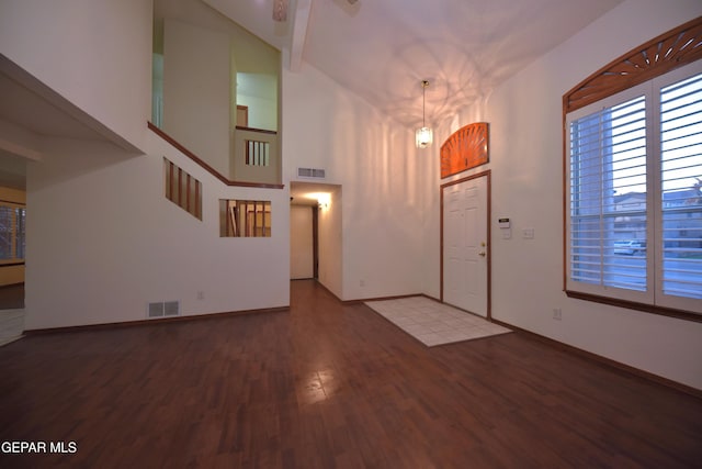 entryway featuring hardwood / wood-style flooring and a towering ceiling