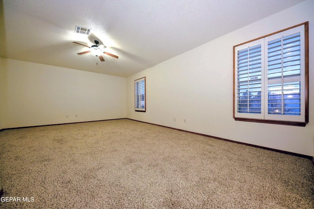 spare room with ceiling fan, a textured ceiling, and carpet