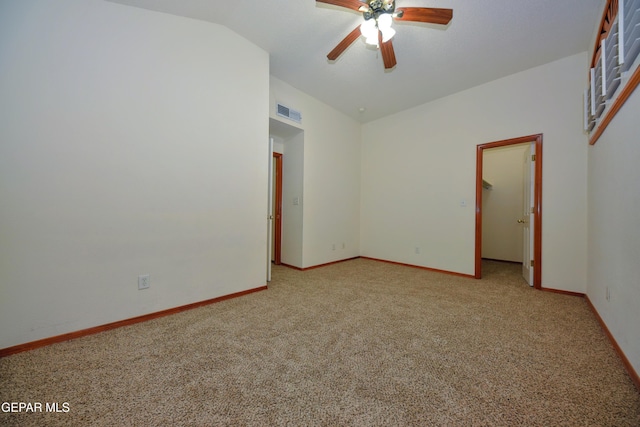 spare room featuring ceiling fan, vaulted ceiling, and light carpet