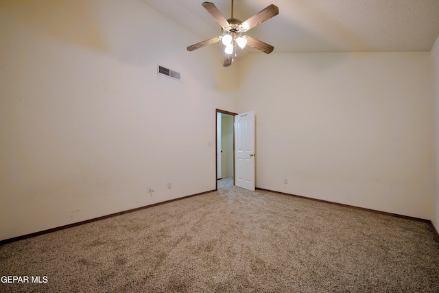 spare room featuring carpet floors, ceiling fan, and a high ceiling