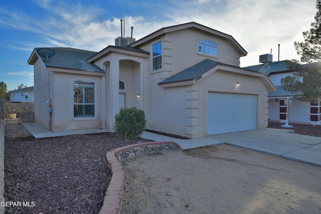 view of property with a garage and central AC unit