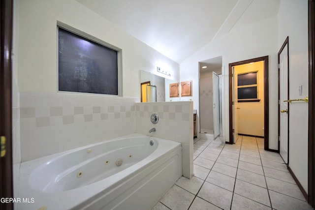 bathroom with a bathtub, vaulted ceiling, and tile patterned floors