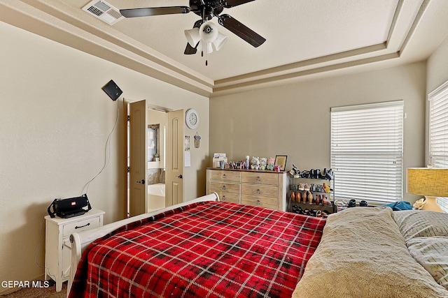 bedroom featuring ceiling fan and a tray ceiling