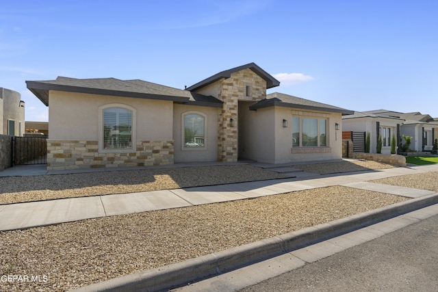 view of front facade with stone siding, fence, and stucco siding